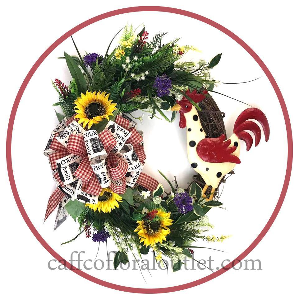 A grapevine wreath adorned with faux florals, a mixed print bow and a painted metal rooster