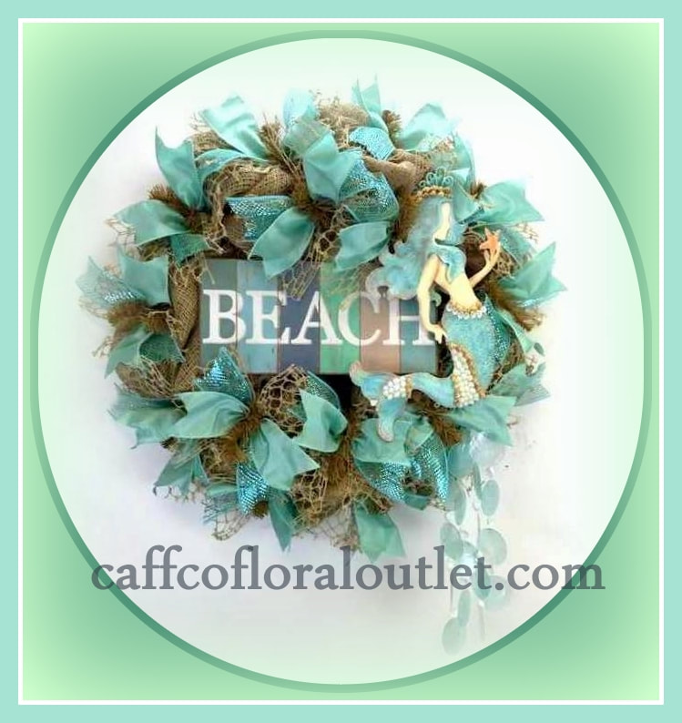 A beach them wreath features burlap, aqua ribbon, a mermaid and a beach sign