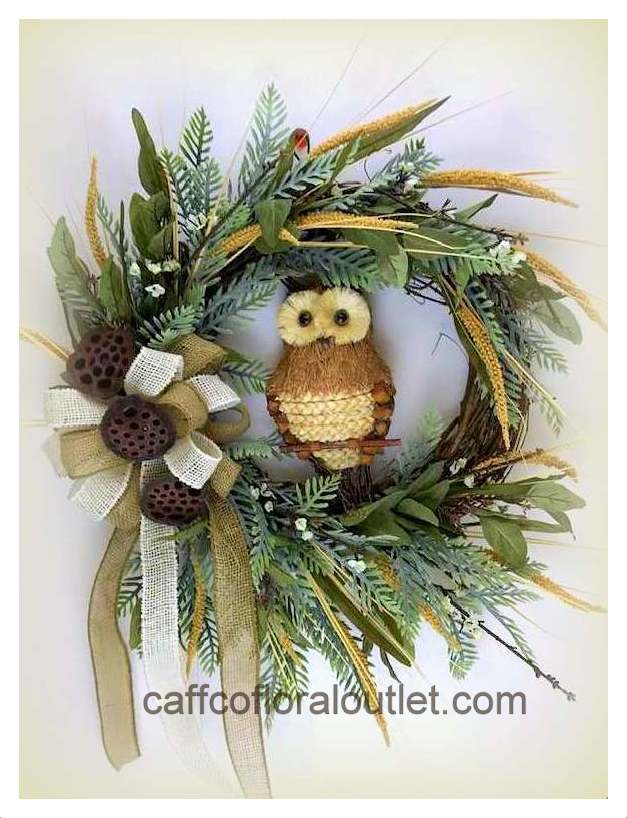 a grapevine wreath with a straw owl, ribbon, faux greenery